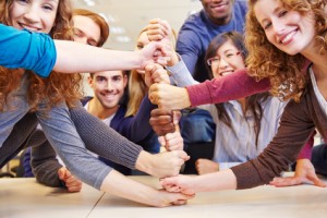 Studenten stapeln Fäuste für Zusammenarbeit und Teamwork in der Universität